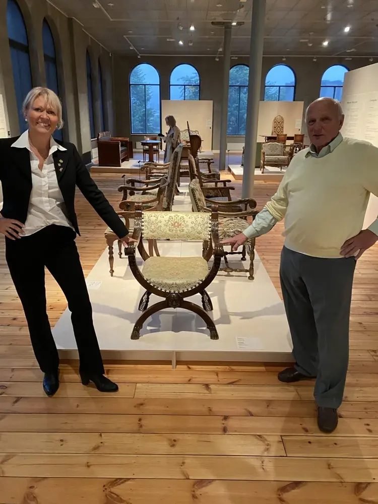 Alette Hjelmeland og Christopher S. Knag ved en Knag-stol i utstillingssalen på KODE
