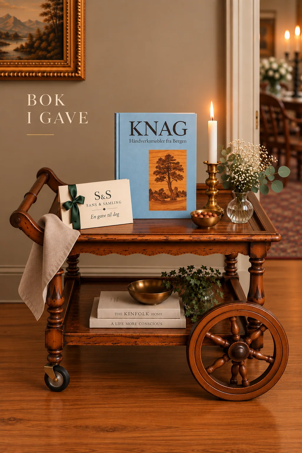 Bok i gave: boken Knag – håndverksmøbler fra Bergen på et trillebord i tre, med gavekort og levende lys