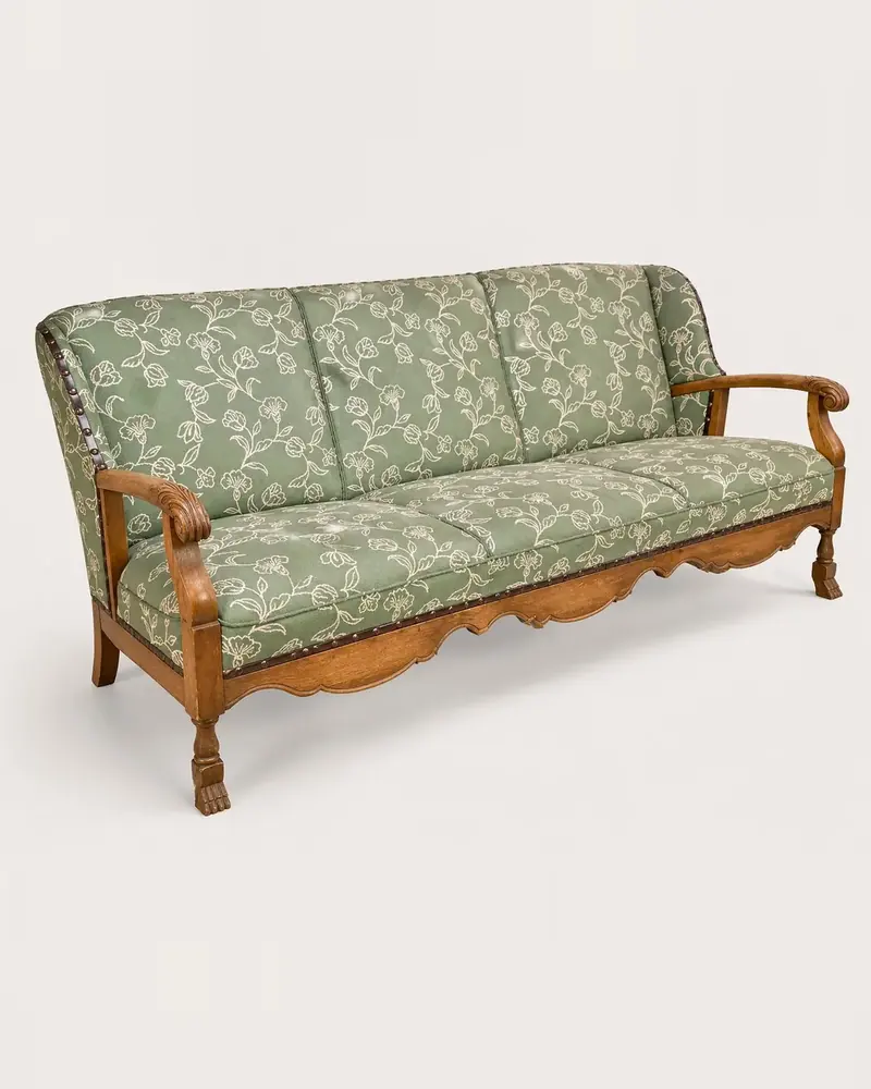 Sofa med grønt, blomstret trekk, messingnagler og utskårne armlener og føtter, fra Chr. Knag i Bergen